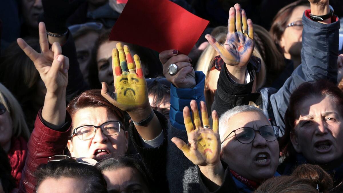 Women show their hands painted to represent a child's face as thousands of members of Turkey's main opposition Republican People's Party marched to parliament in Ankara, Turkey, Tuesday, Nov. 22, 2016.