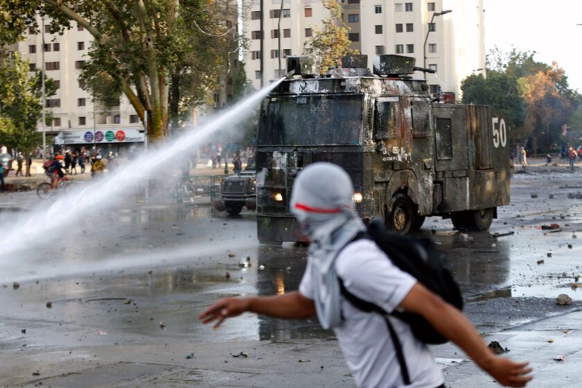 Mandatory Credit: Photo by ALBERTO VALDES/EPA-EFE/REX (10461405e) People are sprayed with water by authorities during protests against the Government of Sebastian Pinera, in Santiago, Chile, 30 October 2019. Ongoing anti-government protests were sparked early in the month after the government announced a price rise in metro tickets. Anti-governemnt protests in Santiago, Chile - 30 Oct 2019 ** Usable by LA, CT and MoD ONLY **