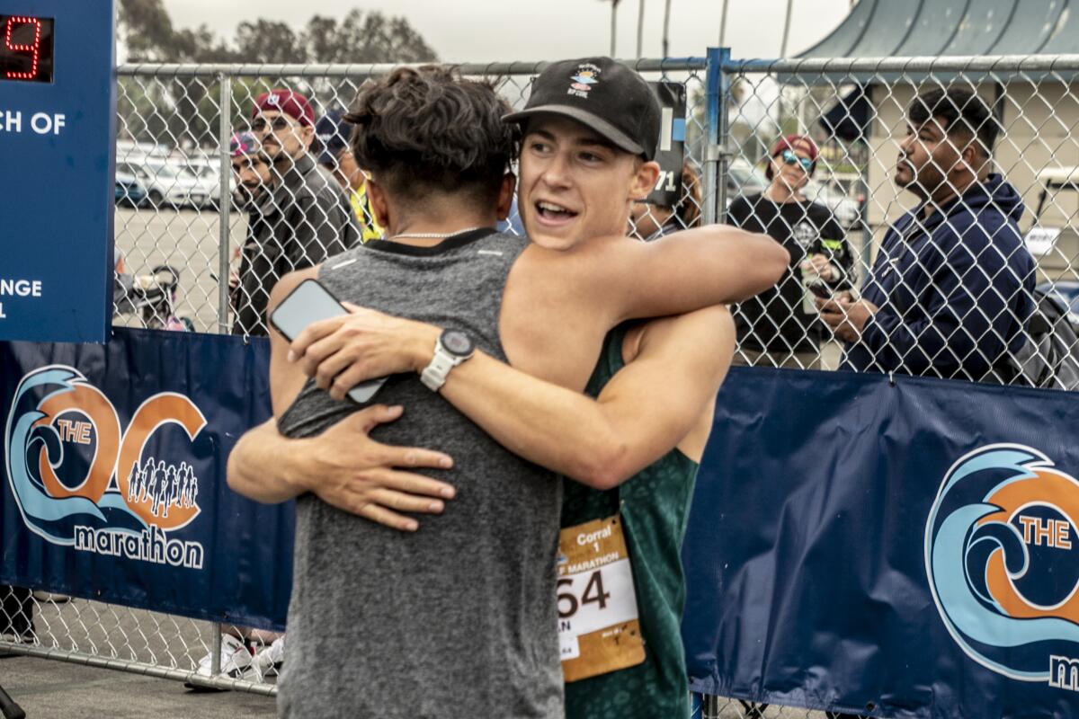 Ryan Tessier and Isiah Quiambao hug after finishing the half-marathon.