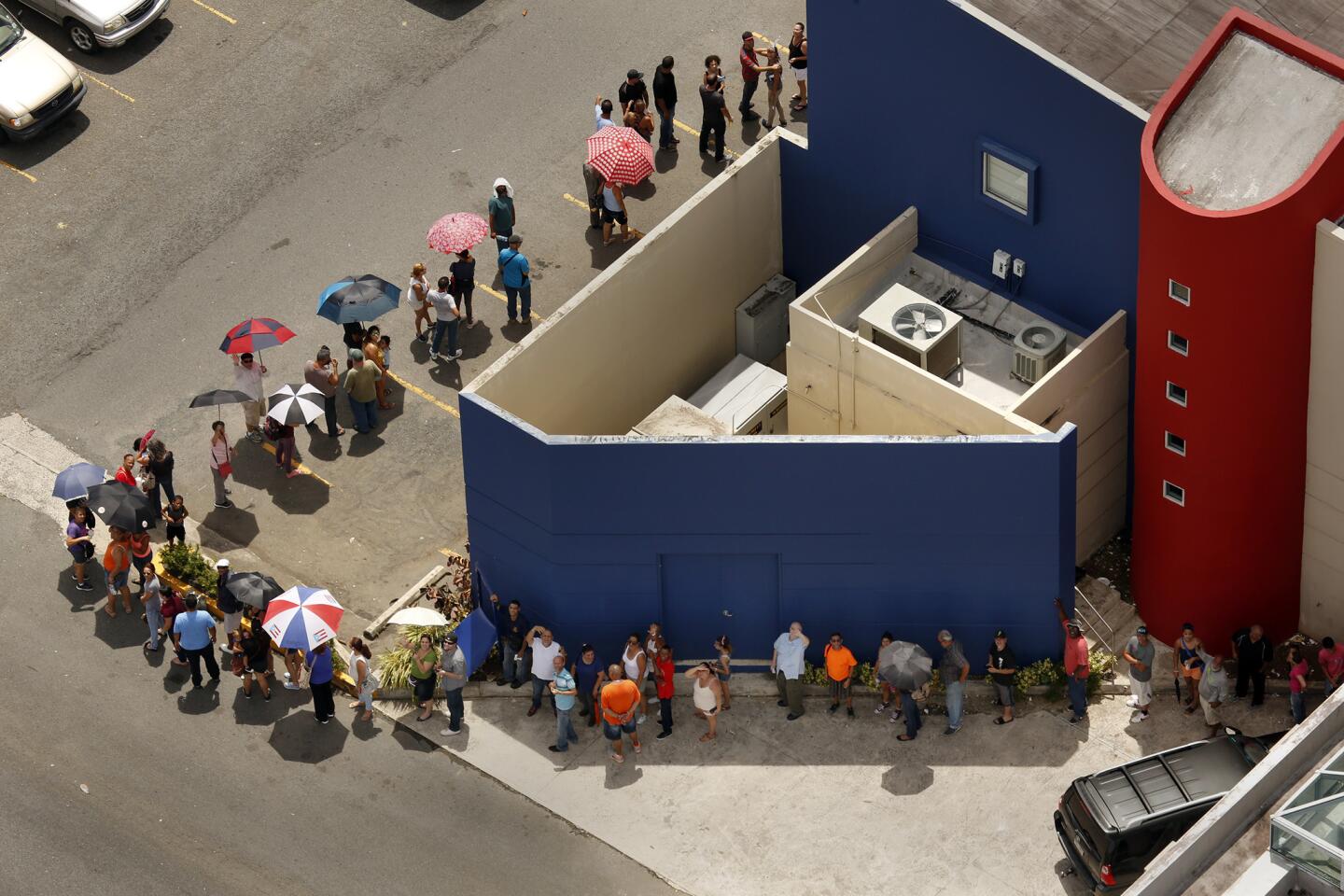 A line of people hoping to withdraw money wraps around the Banco Popular in San Juan on Monday.