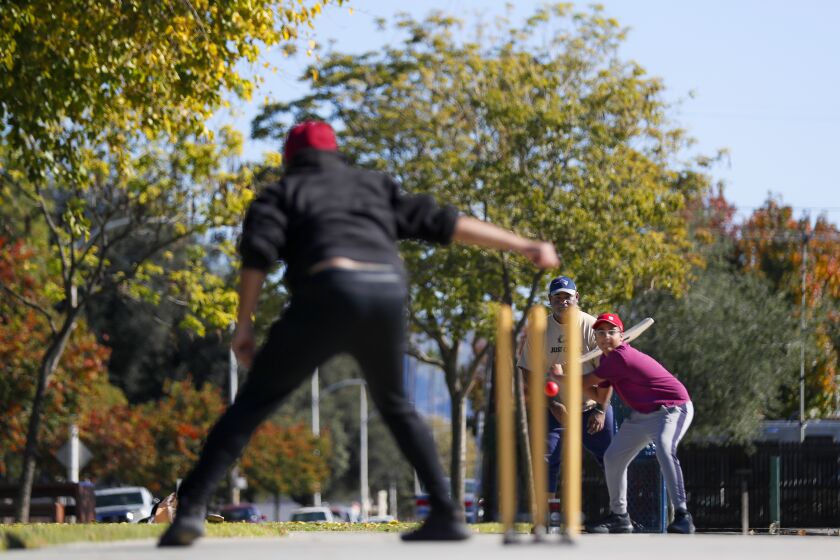 Azusa, CA, Sunday, November 27, 2022 - Batsman Abdul prepares to swing at the ball delivery by the bowler, Mohammed as Shiraz looks on during a weekly cricket match Northside Park. (Robert Gauthier/Los Angeles Times)
