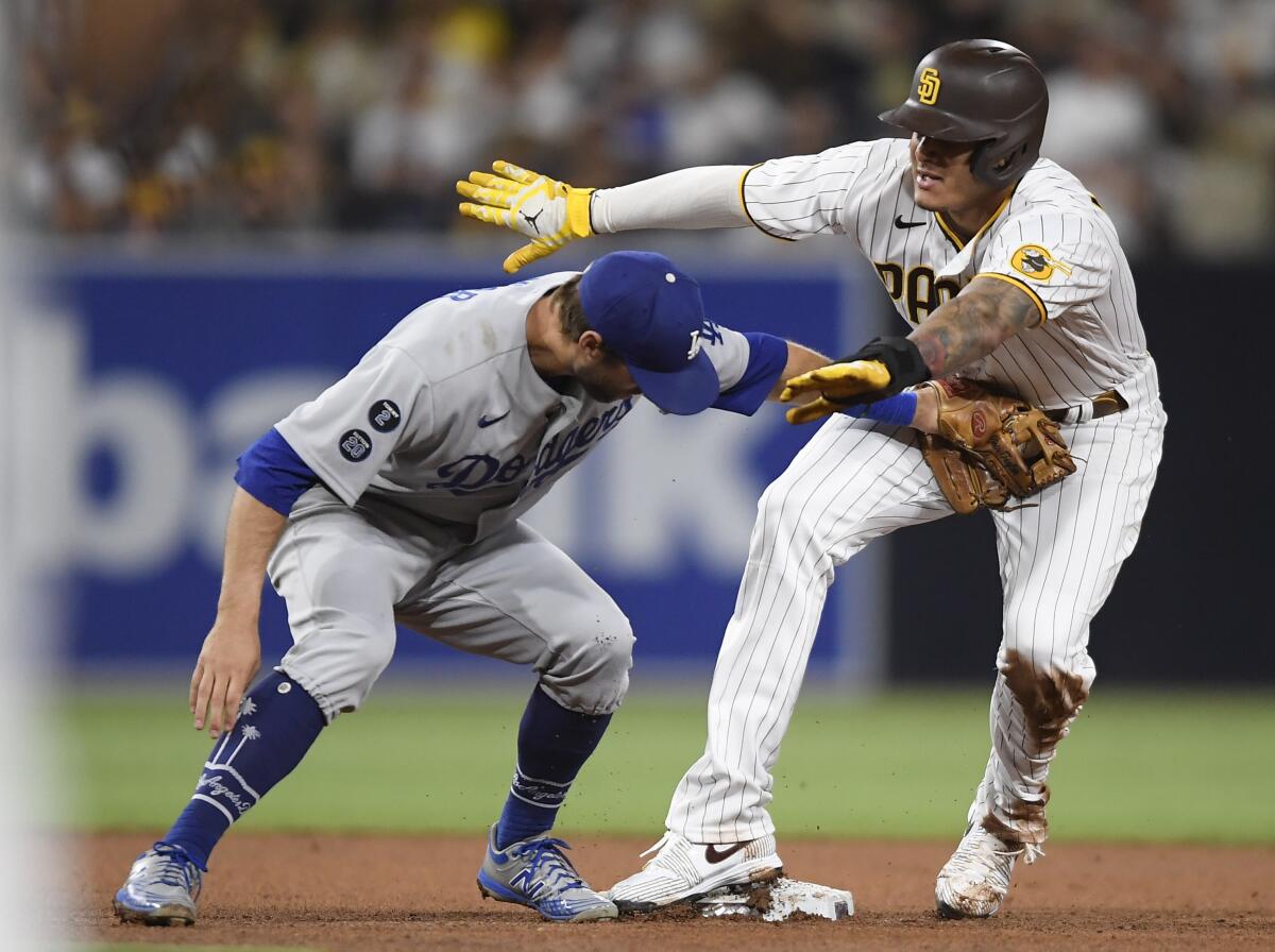 The Padres' Manny Machado steals second base ahead of the tag of Dodgers second baseman Chris Taylor.