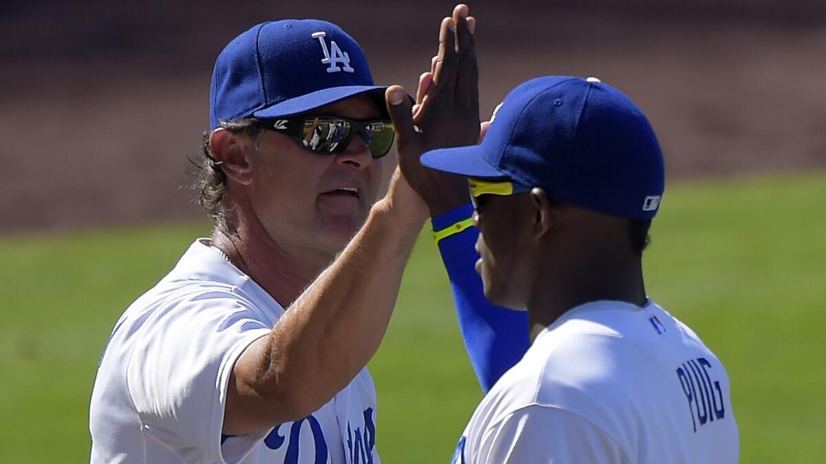 Dodgers Manager Don Mattingly, left, congratulates Yasiel Puig after a win over the San Diego Padres last season.