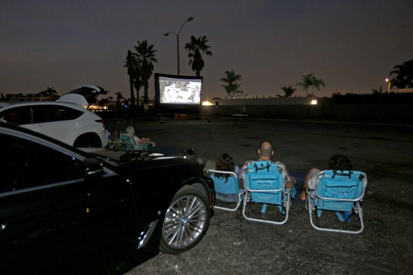 Movie-goers enjoy "Ferris Buehler's Day Off" at a temporary drive-in theater called "Wheels & Reels" at the Stoney Harbour parking lot in Huntington Beach on Friday, Aug. 21, 2020. Organizer Matthew Cramer will continue the outdoor movies until the end of Summer.