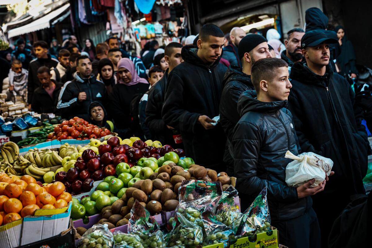 As pessoas caminham até a Mesquita Al Aqsa carregando suas refeições Iftar.