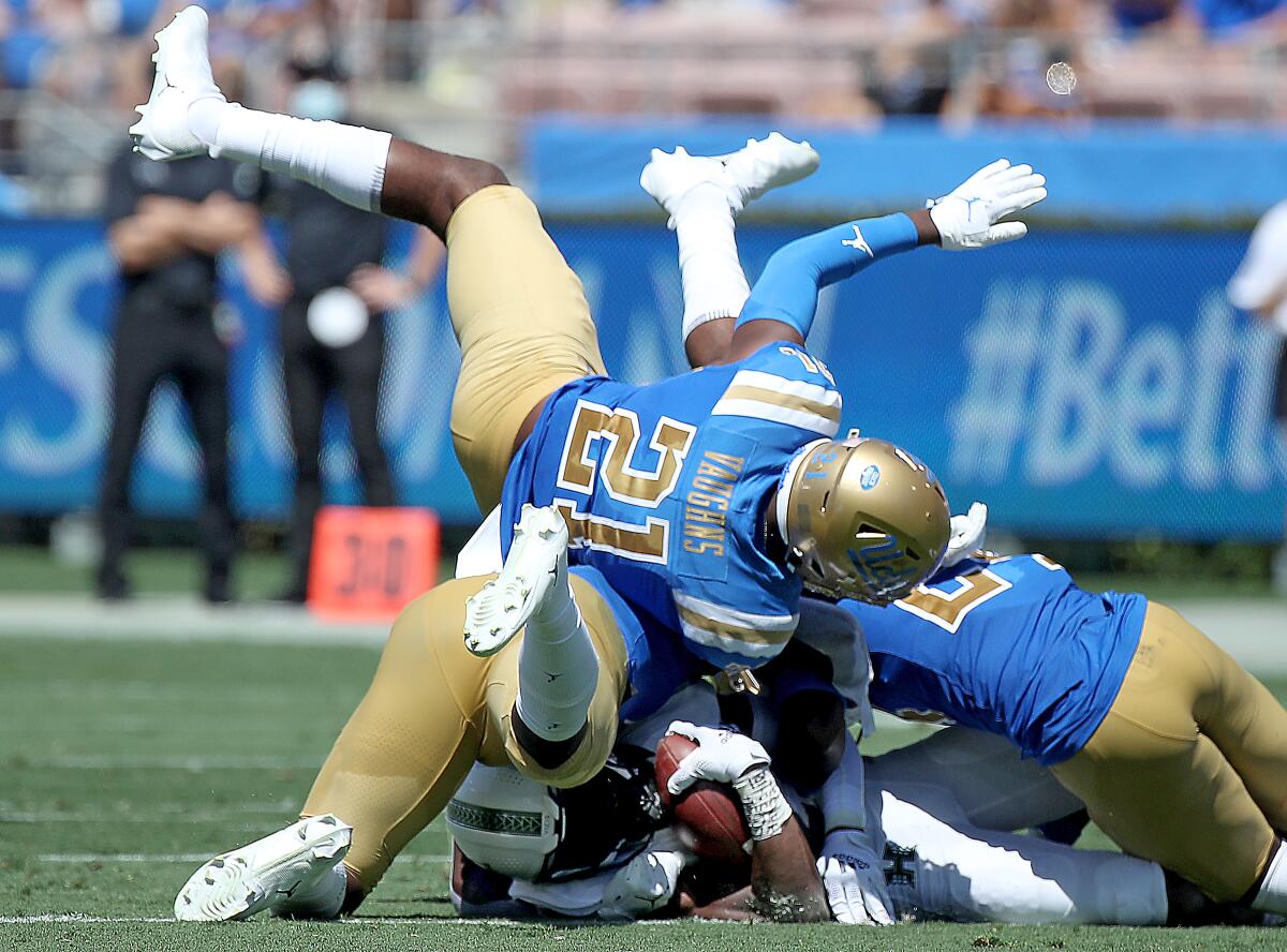 The UCLA defense stops Hawaii running back Dedrick Parson.