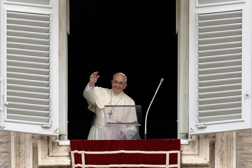 Pope Francis waves from the window of his study overlooking St. Peter's Square at the Vatican.