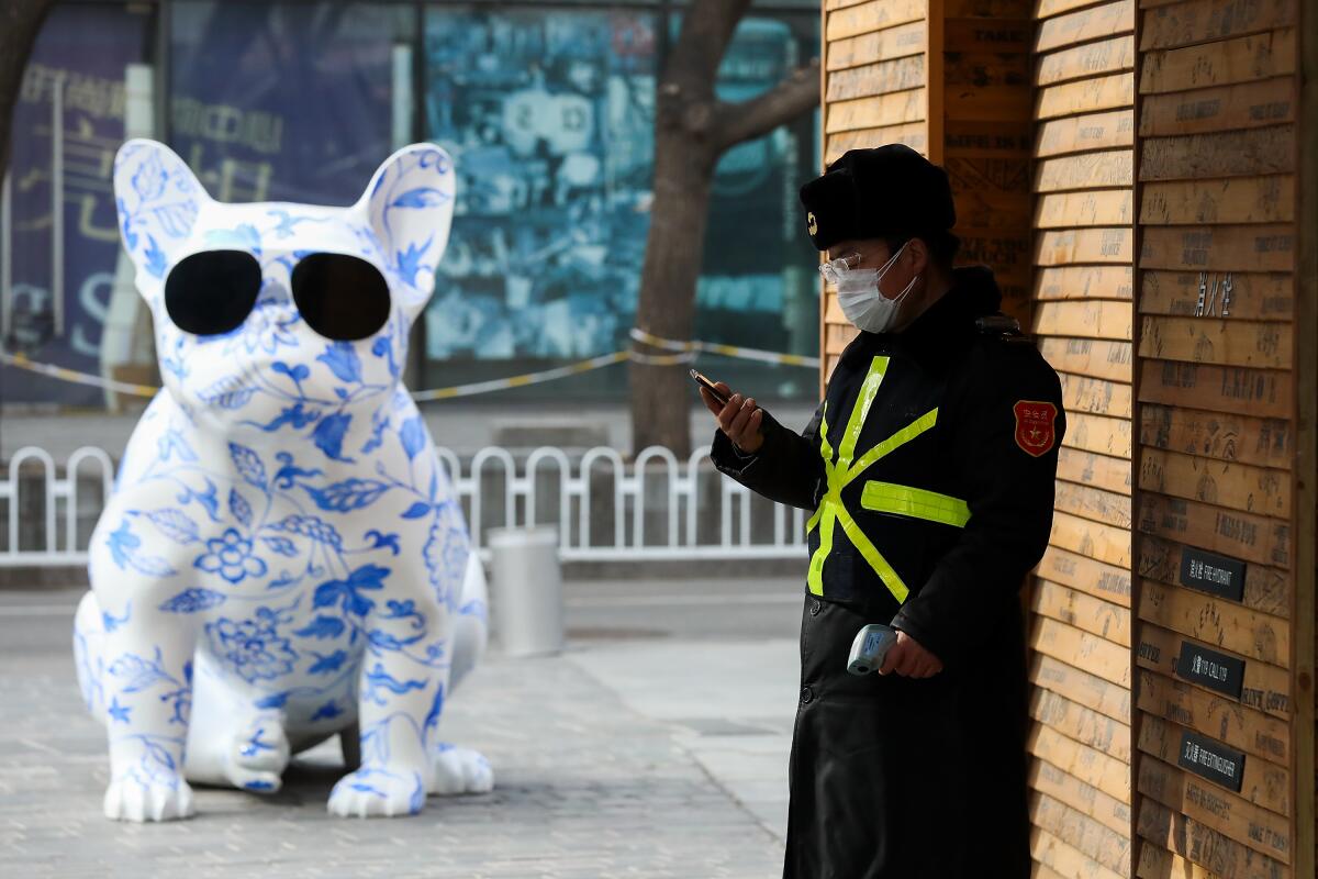 A security guard wears a protective mask outside an empty shopping mall in Beijing on Feb. 18.