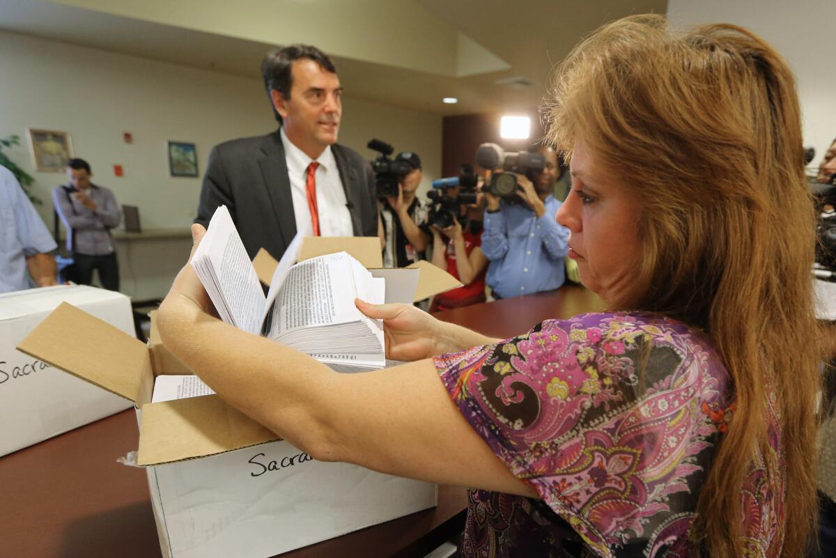 The elections manager for the Sacramento County Registrar of Voters makes a quick inspection of some of the petitions turned in that would place a ballot initiative before voters asking to split California into six separate states on July 15, 2014.