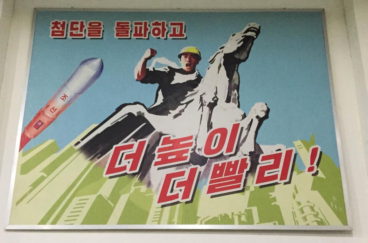 A piece of propaganda art inside the factory. The plant had numerous large posters exhorting workers to follow the party and work hard for the country. “Go Higher, Go Faster!” it says. (Julie Makinen / Los Angeles Times)