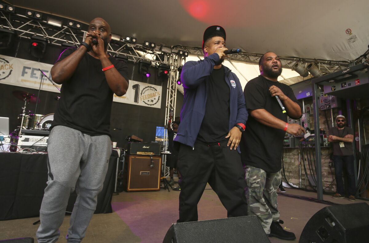A hip-hop trip performs onstage.