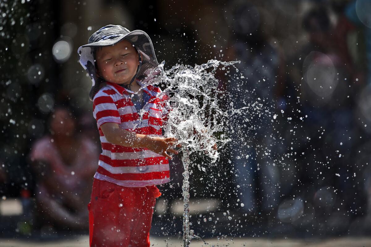 Jasper Lee, 2, plays in a water fountain at Victoria Gardens on a hot afternoon in Rancho Cucamonga in March. Wednesday's temperatures will be the warmest of the week and could reach into the 90s in some areas.