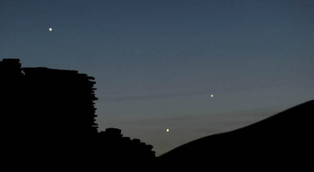 Left to right, the planets Jupiter, Venus and Mercury are seen in an unusual setting over the Wupatki pueblo ruin.