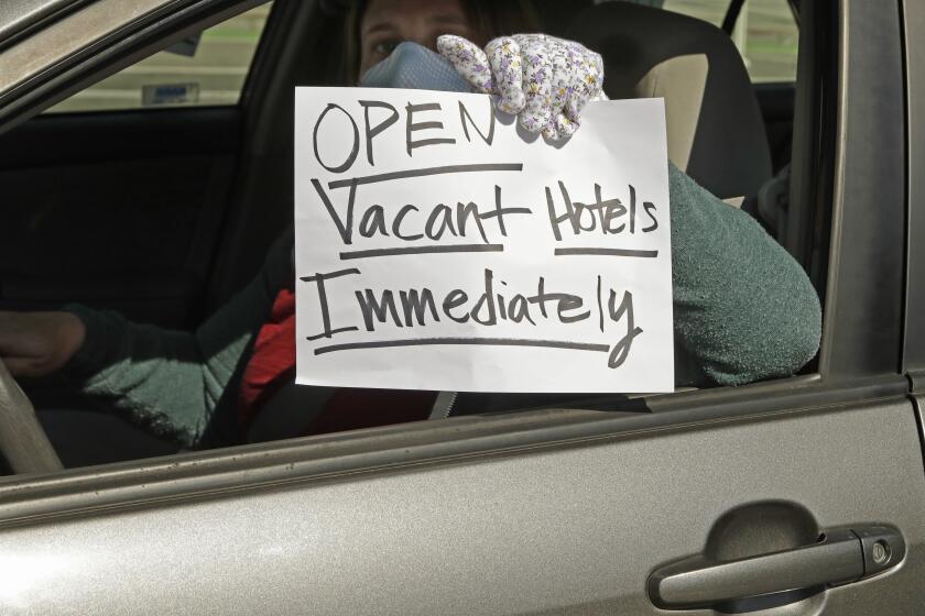 An activist protests from her vehicle outside Moscone Center, asking Mayor London Breed to house homeless people using vacant hotels, Friday, April 3, 2020, in San Francisco.