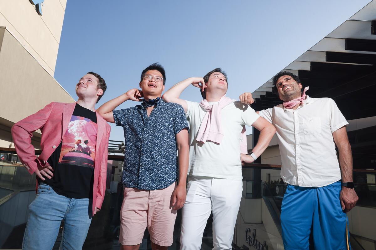A group of four men dressed as Ken in different shorts, pants and shirts for the "Barbie" movie.