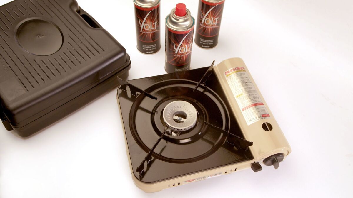 A Hanaro portable gas stove, with carrying case and butane canisters.