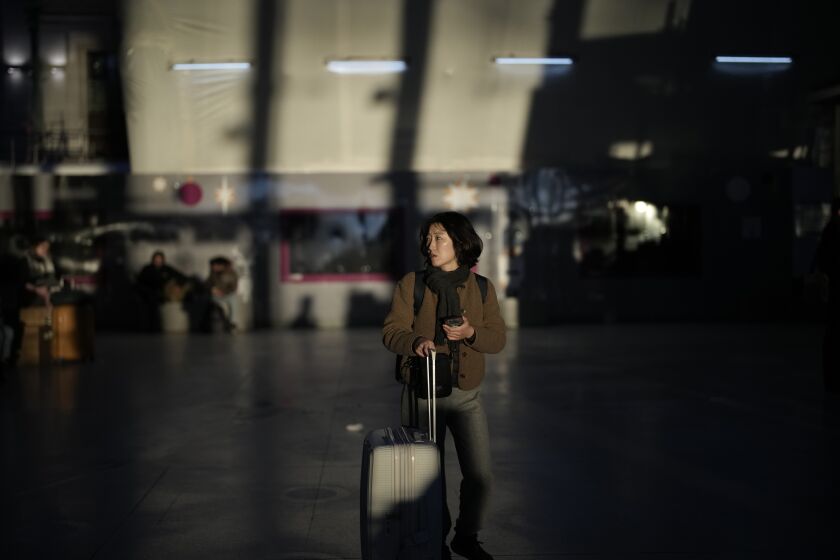 A passenger waits at the Gare de Lyon station in Paris, Tuesday, Feb. 7, 2023. The French parliament has started debating President Emmanuel Macron's unpopular pension reform proposals, which prompted strikes and large demonstrations in recent weeks. The bill would raise the minimum retirement age from 62 to 64. A third round of protests has been called on Tuesday Feb.7, 2023 by eight main workers' unions. (AP Photo/Christophe Ena)