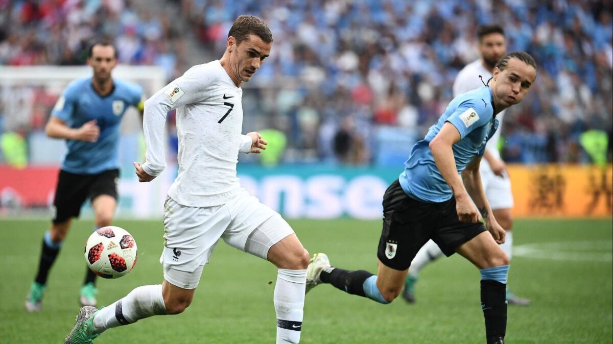 France's Antoine Griezmann, left, vies with Uruguay's Diego Laxalt during the 2018 World Cup on July 6.