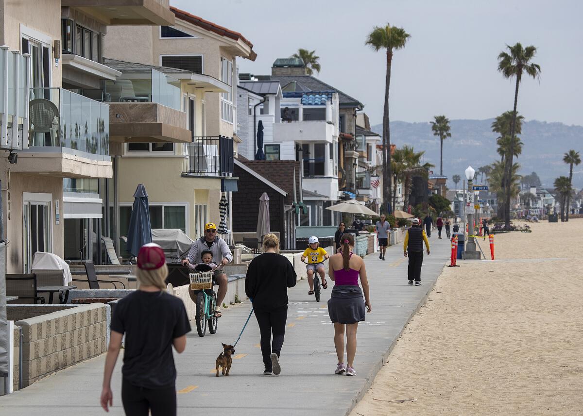 People exercise along the boardwalk near the Newport Beach pier