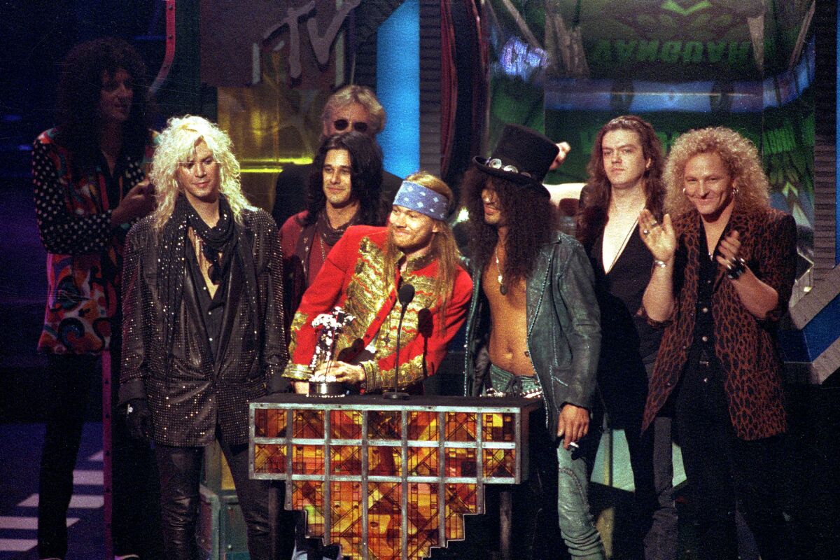 A group of colorfully dressed people accept an award at the MTV Video Music Awards in 1992.