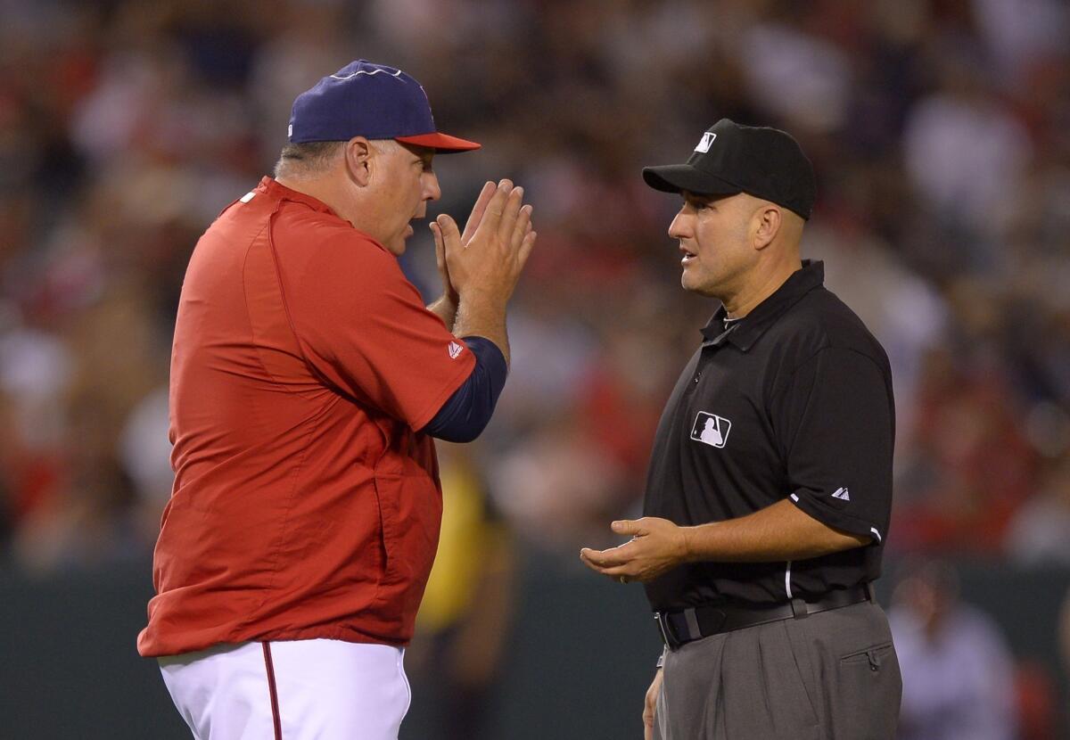 Angels Manager Mike Scioscia pleads his case with second base umpire Eric Cooper after Houston Astros' L.J. Hoes was called safe at second during the ninth inning. The call was eventually reversed.