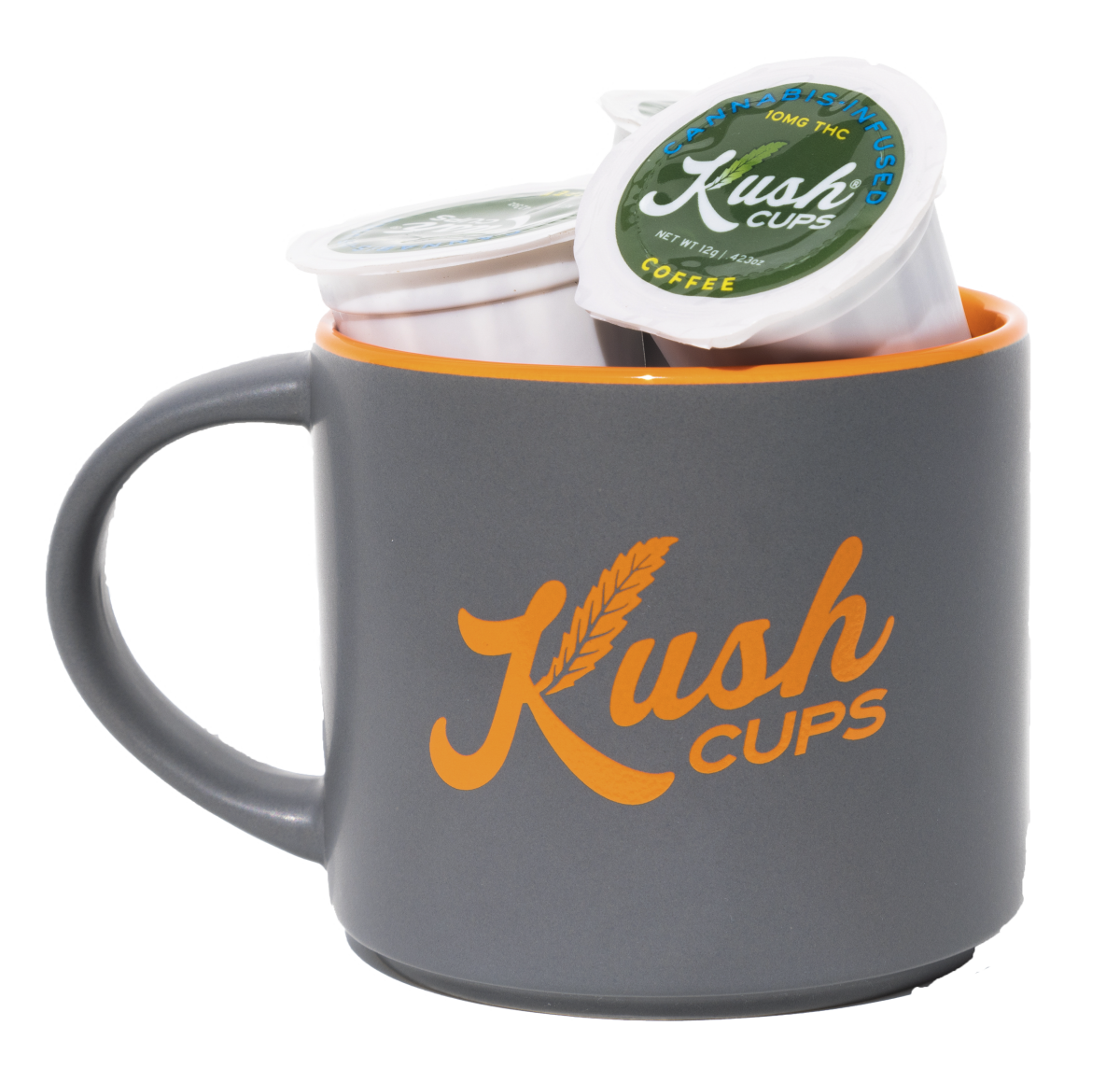 A coffee mug with the name Kush Cups on it filled with two K-Cup coffee pods.