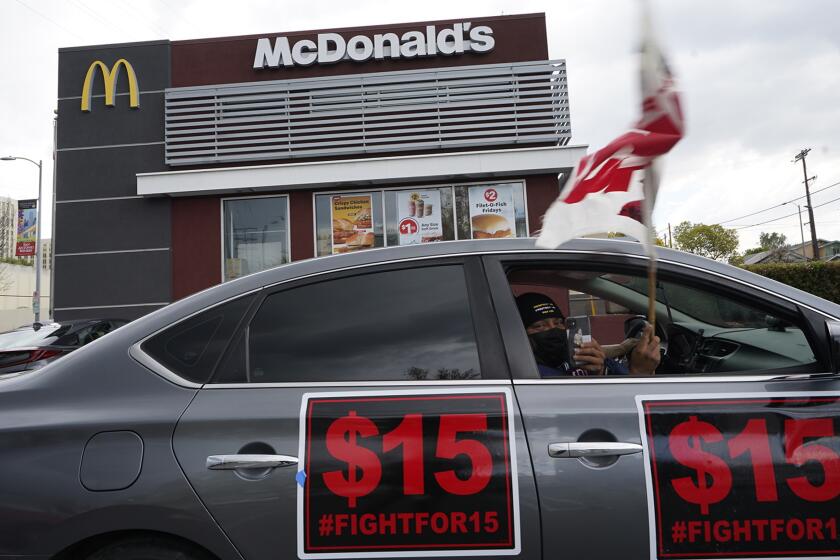 FILE — Fast-food workers drive-through to protest for a $15 dollar hourly minimum wage outside a McDonald's restaurant in East Los Angeles Friday, March 12, 2021. On Monday, Jan. 31, 2022 California lawmakers approved a first-in-the-nation measure by Assemblyman Chris Holden that gives California's more than half-million fast food workers increased power and protections. (AP Photo/Damian Dovarganes, File)