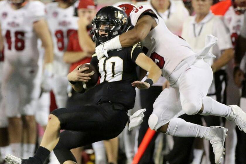 Central Florida quarterback McKenzie Milton is tackled by an Arkansas State defender during the first half of the Cure Bowl on Dec. 17.
