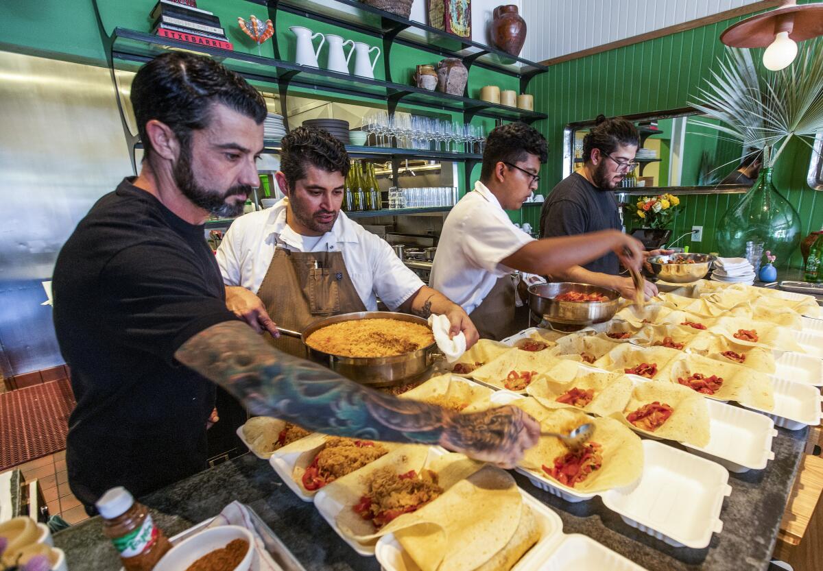 Bar Le Côte staffers prepare meals to-go. 