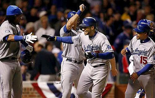 Dodgers first baseman James Loney is greeted by teammates Manny Ramirez, ,Andre Ethier and Rafael Furcal after he hit a grand slam in the fifth inning Wednesday against the Cubs at Wrigley Field in Game 1 of their playoff series.