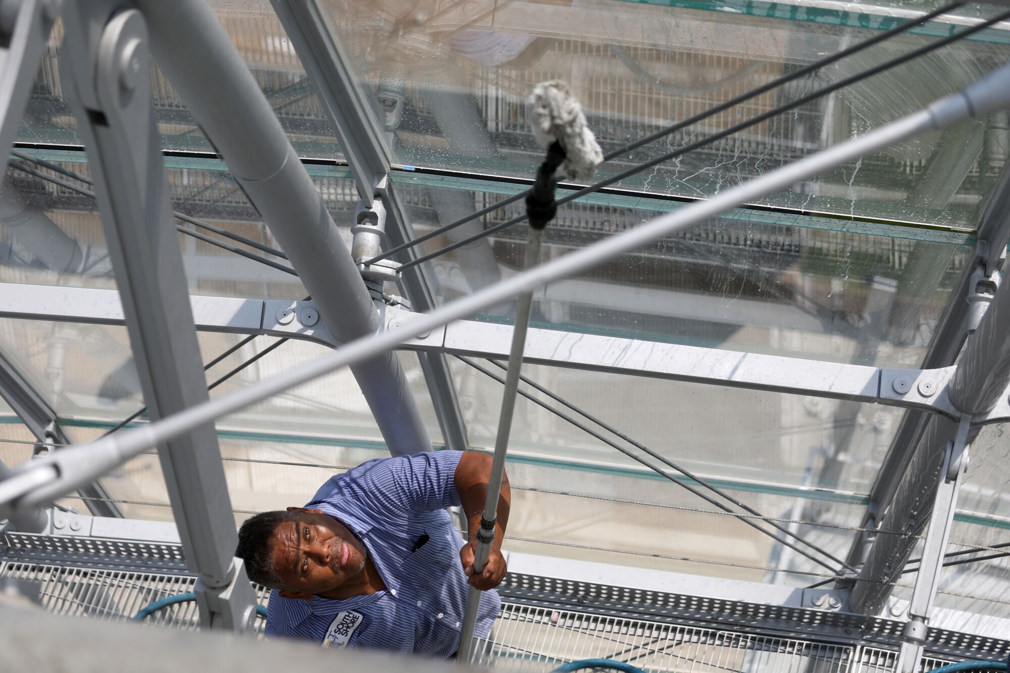 A maintenance worker cleans the glass dome covering the Dolby Family Terrace on the sphere 