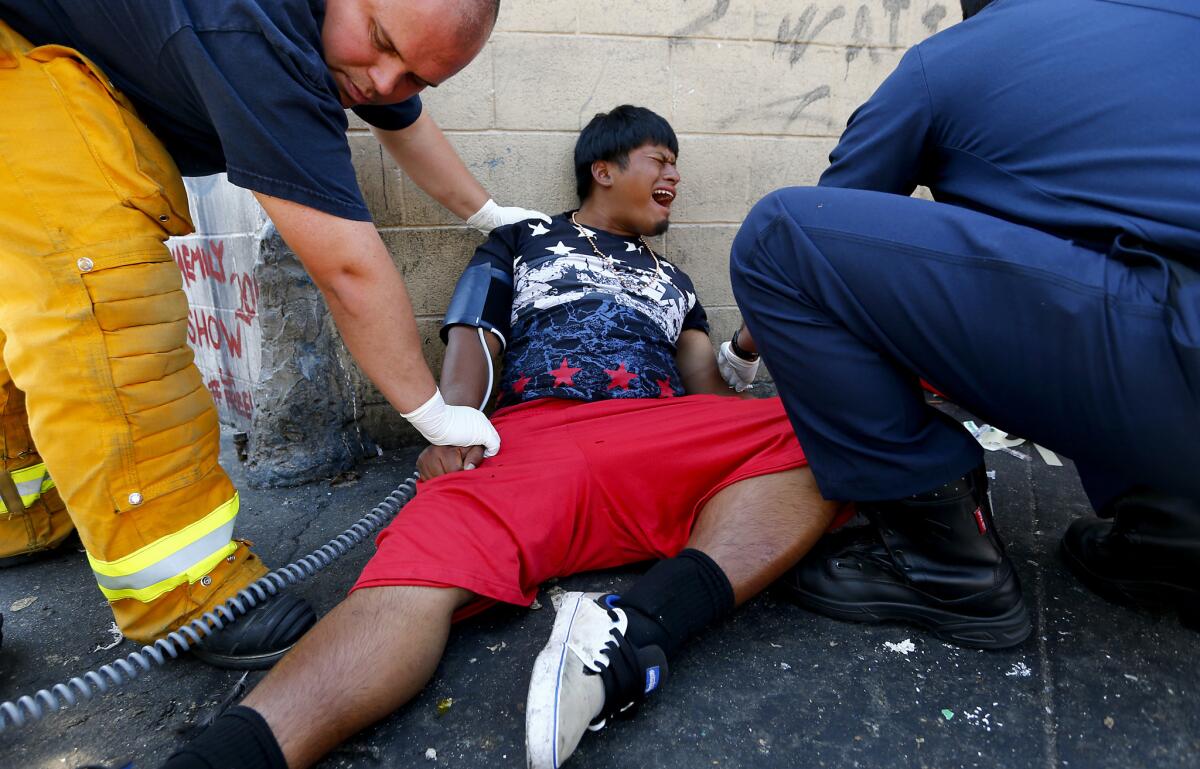 Los Angeles Fire Department personnel assist a man believed to be feeling the effects of a synthetic cannabinoid called "spice" during an Aug. 22 rash of overdoses on skid row.