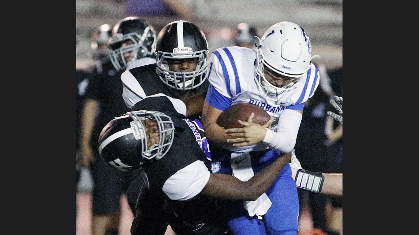 Burbankâ€™s quarterback Matthew Porras runs the ball on a quarterback keeper and smashes into Hoover's Micah Willingham-Harvey, falling back a bit before dragging Porras down in a Pacific League football game on Moyse Field at Glendale High School on Thursday, September 28, 2017.