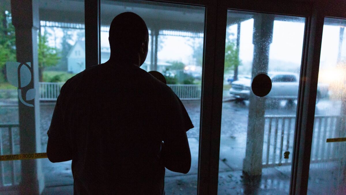 Rashan Clark stares out the window of a hotel where he is staying in Wilmington, N.C., while Hurricane Florence passes through.