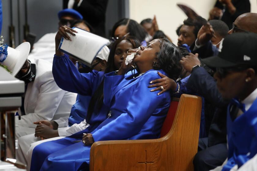 LOS ANGELES-CA-NOVEMBER 12, 2021: Sharon Moore is comforted during a funeral service for her husband, Joe Reginald Moore Sr., a 67-year-old Compton pastor who was shot in the chest outside the church where he had just led a bible study, at Hay's Tabernacle Christian Methodist Episcopal Church in Los Angeles on Friday, November 12, 2021. (Christina House / Los Angeles Times)