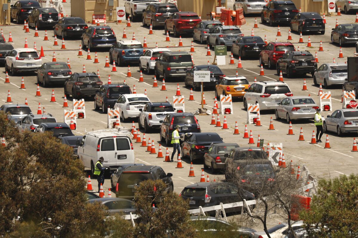 Long lines of cars between orange traffic cones