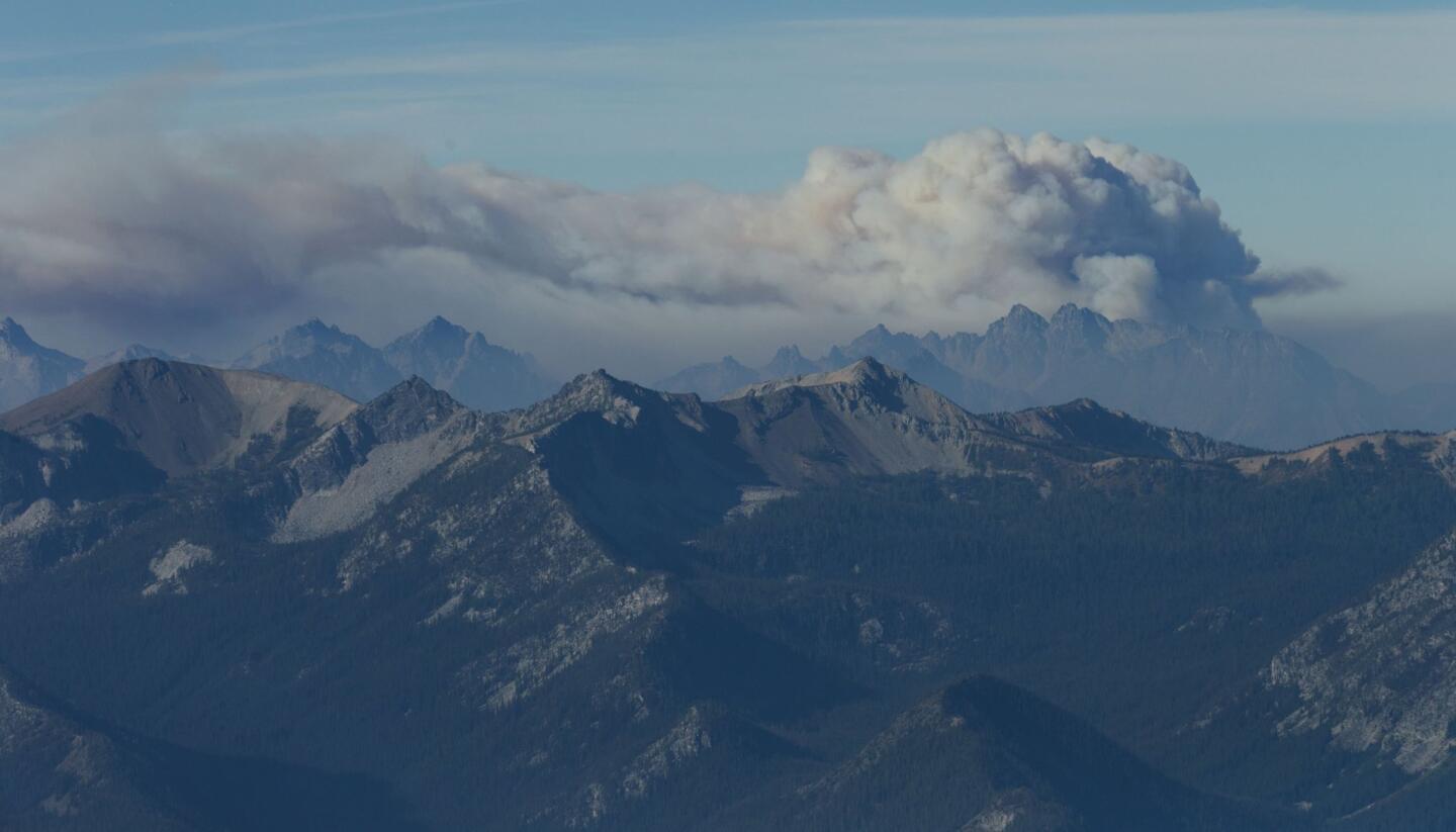 Smoke from a wildfire rises above the North Cascade Mountains in Washington. Firefighters on several fronts are fighting wildfires that are advancing on towns in the north-central part of the state.
