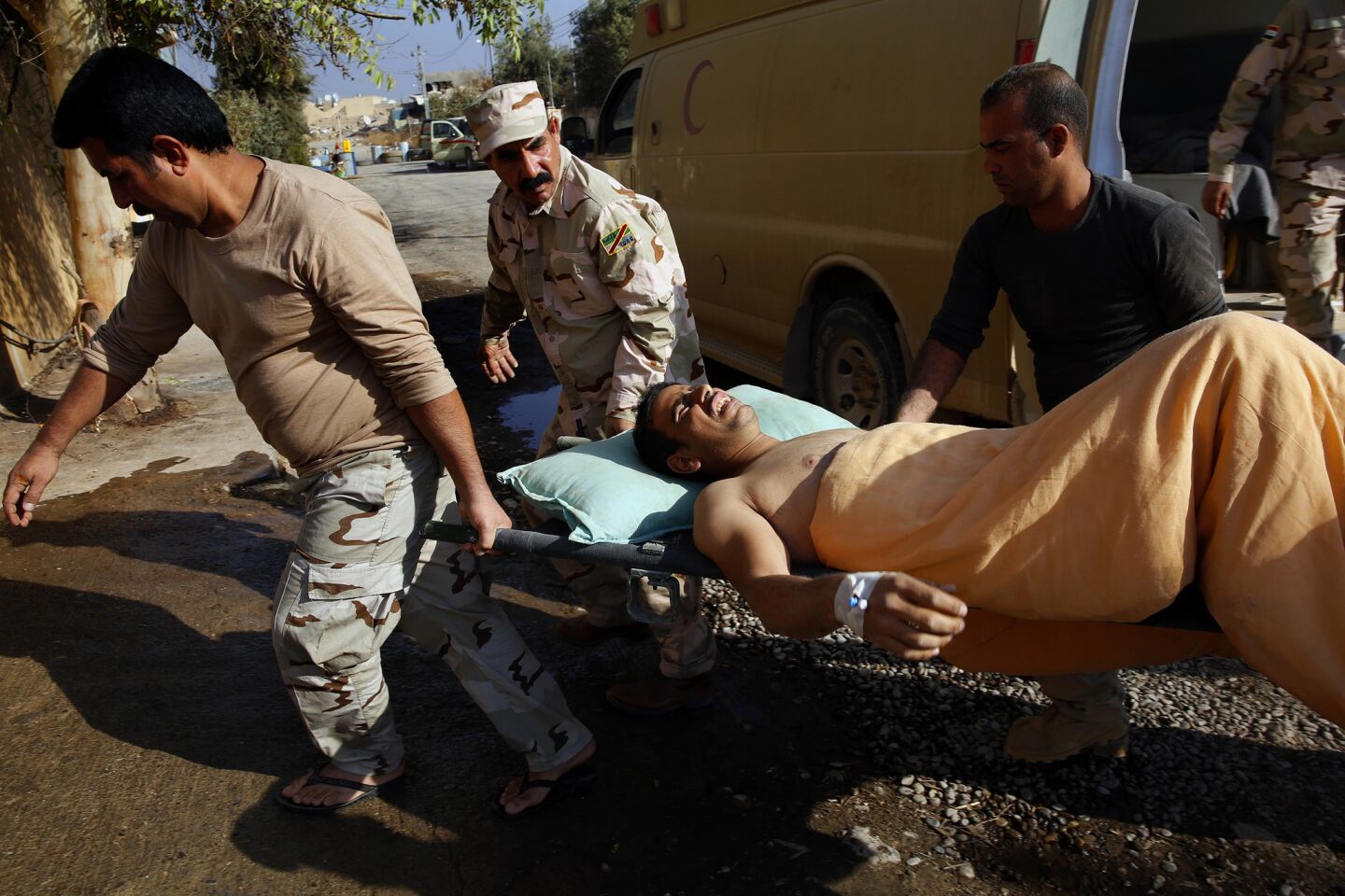Wounded soldiers and civilians are carried into a field hospital.