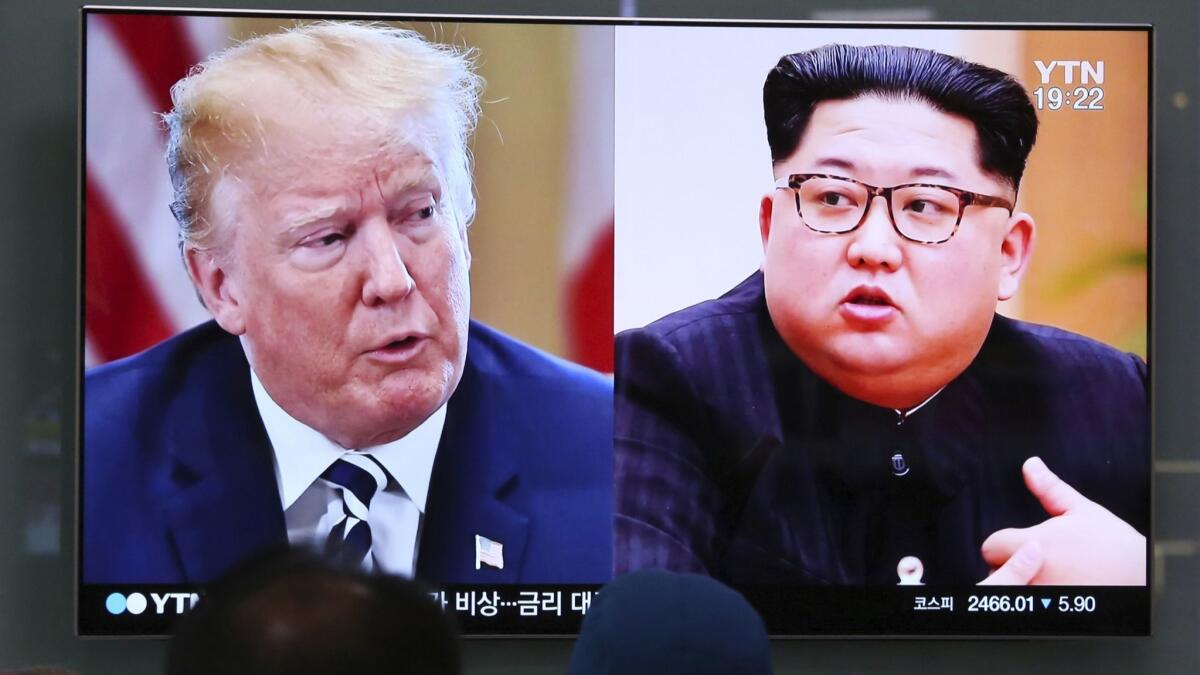 People watch a TV screen showing file footage of U.S. President Donald Trump, left, and North Korean leader Kim Jong Un in Seoul, South Korea.