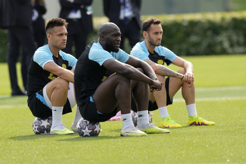 Inter Milan's Lautaro Martinez, left, Inter Milan's Hakan Calhanoglu, right, and Inter Milan's Romelu Lukaku attend at the training during a media day ahead of the Champions League soccer final, at the Suning training center, in Appiano Gentile, northern Italy, Monday, June 5, 2023. Inter Milan will play a Champions League final against Manchester City in Istanbul, Turkey, next Saturday, June 10. (AP Photo/Antonio Calanni)