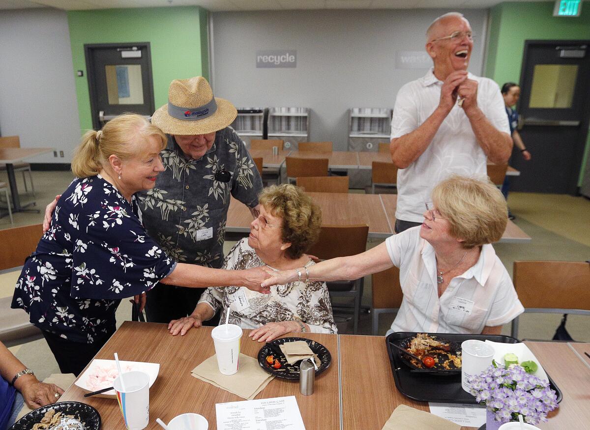 Nina Tucker is greeted by Barbara Lewis and Kathy Burns as the evening's host, Phil Downs, laughs. The group was gathered for dinner in the Hillside Cafe at USC VHH.