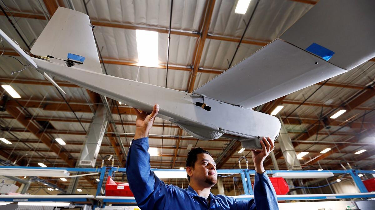 A technician at AeroVironment inspects parts of an unmanned aircraft in 2015.