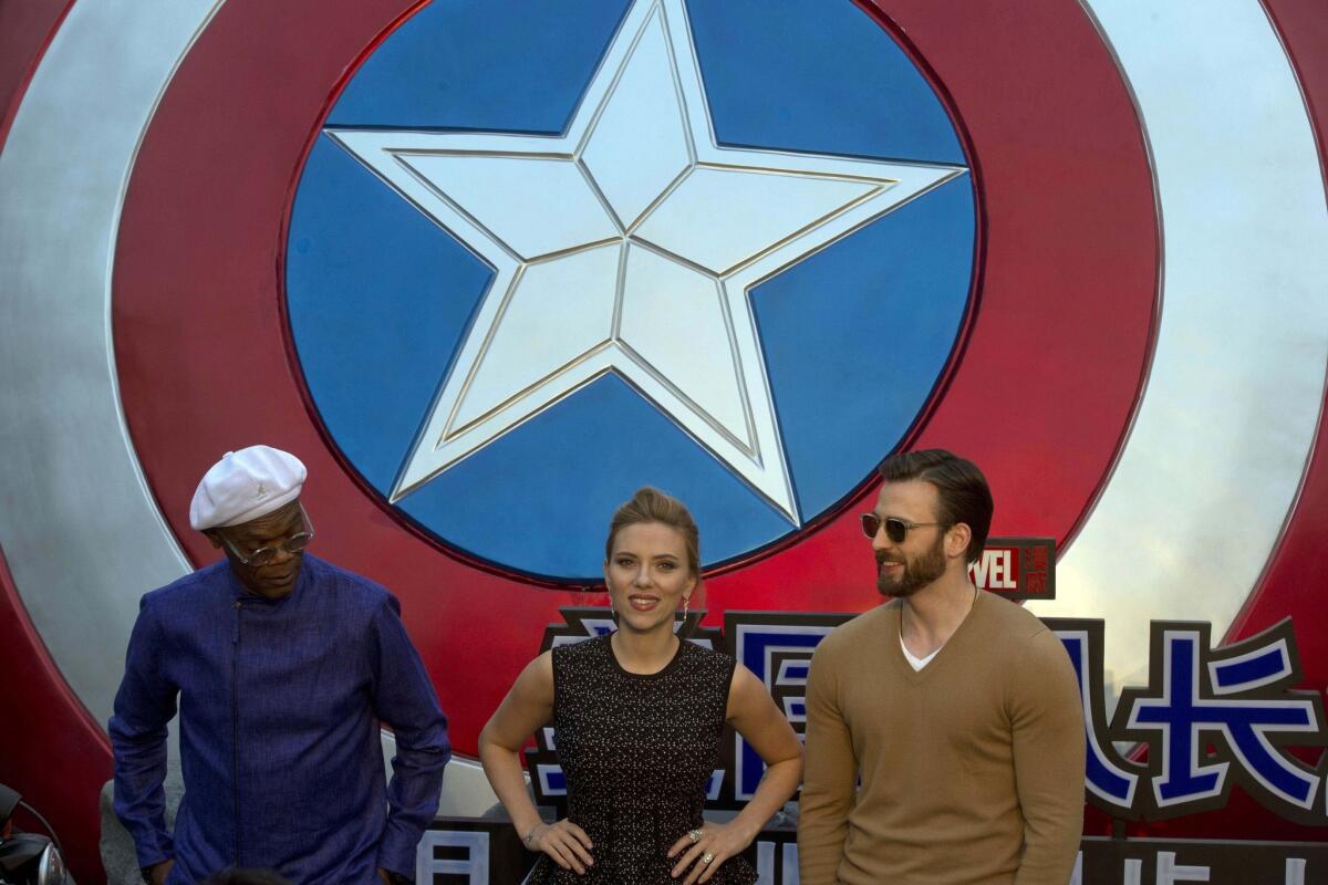 Samuel L. Jackson, left, Scarlett Johansson, center, and Chris Evans pose during a publicity event in Beijing ahead of the April release of the movie "Captain America: The Winter Soldier."
