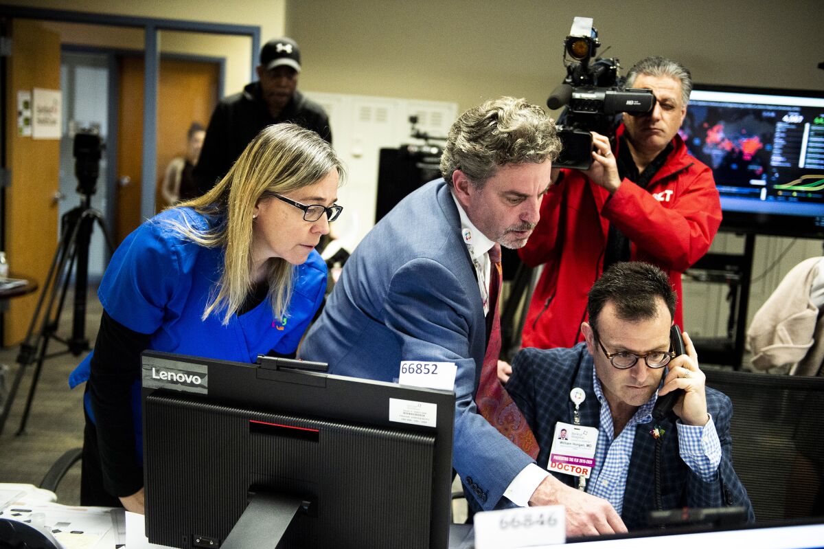 Medical professionals including Dr. Daniel Kombert, medical director for the Care Logistics Center and director for the Clinical Command Center, track data in March at the Hartford HealthCare COVID-19 Command Center in Connecticut.
