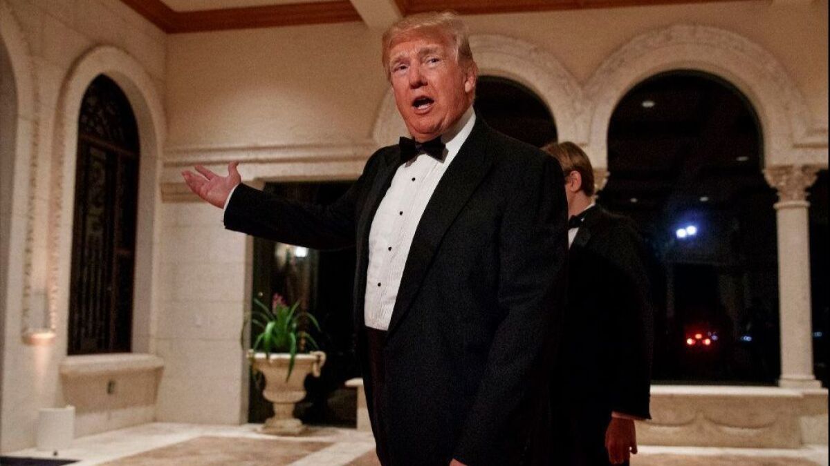 President Trump speaks with reporters after arriving at his Mar-a-Lago resort in Palm Beach, Fla., for a New Year's Eve gala.