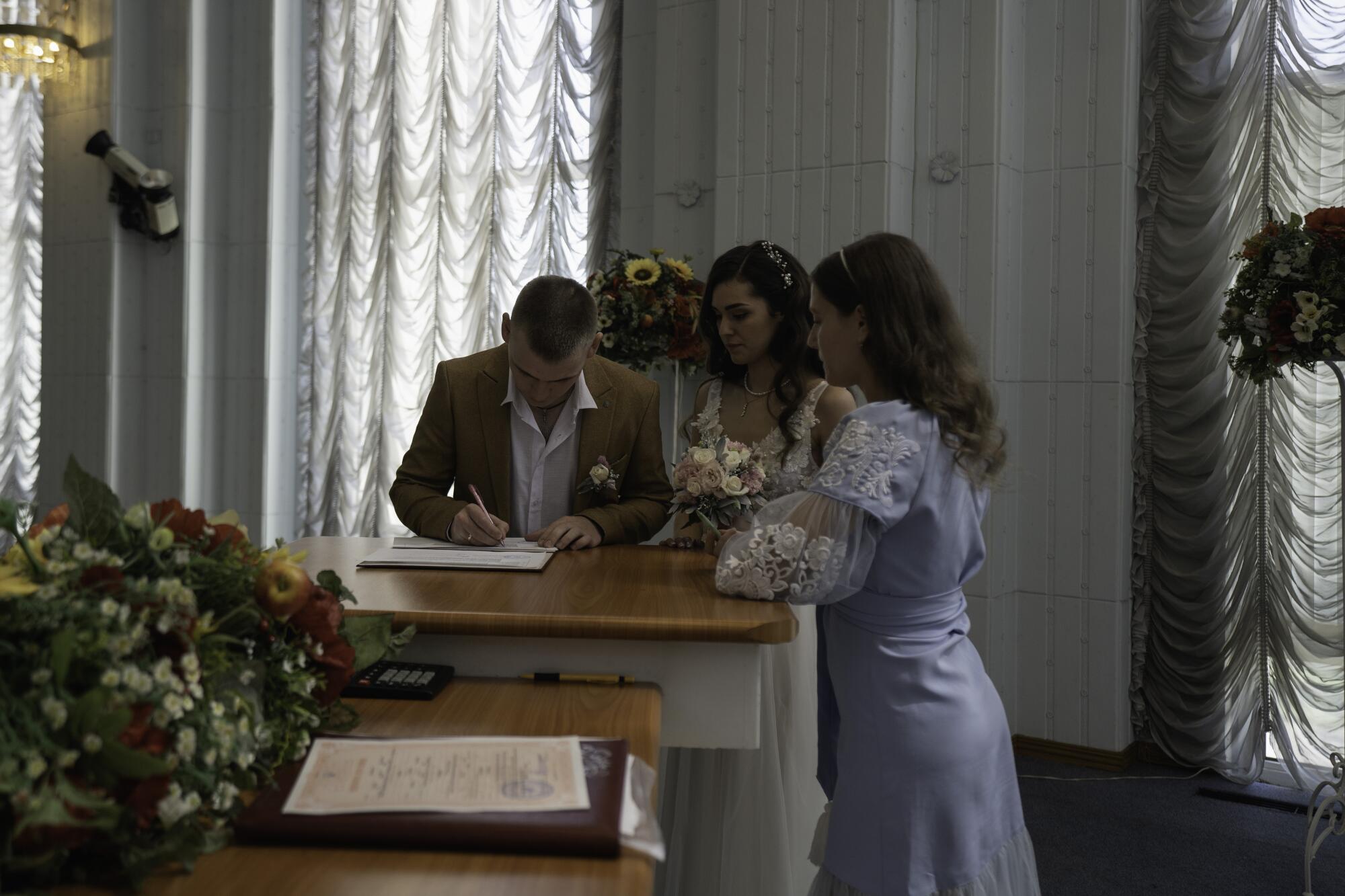 A couple signs a registry after getting married at the central office