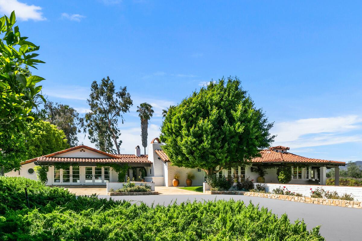 The 91-acre spread includes two homes surrounded by gardens, trees and an avocado grove.