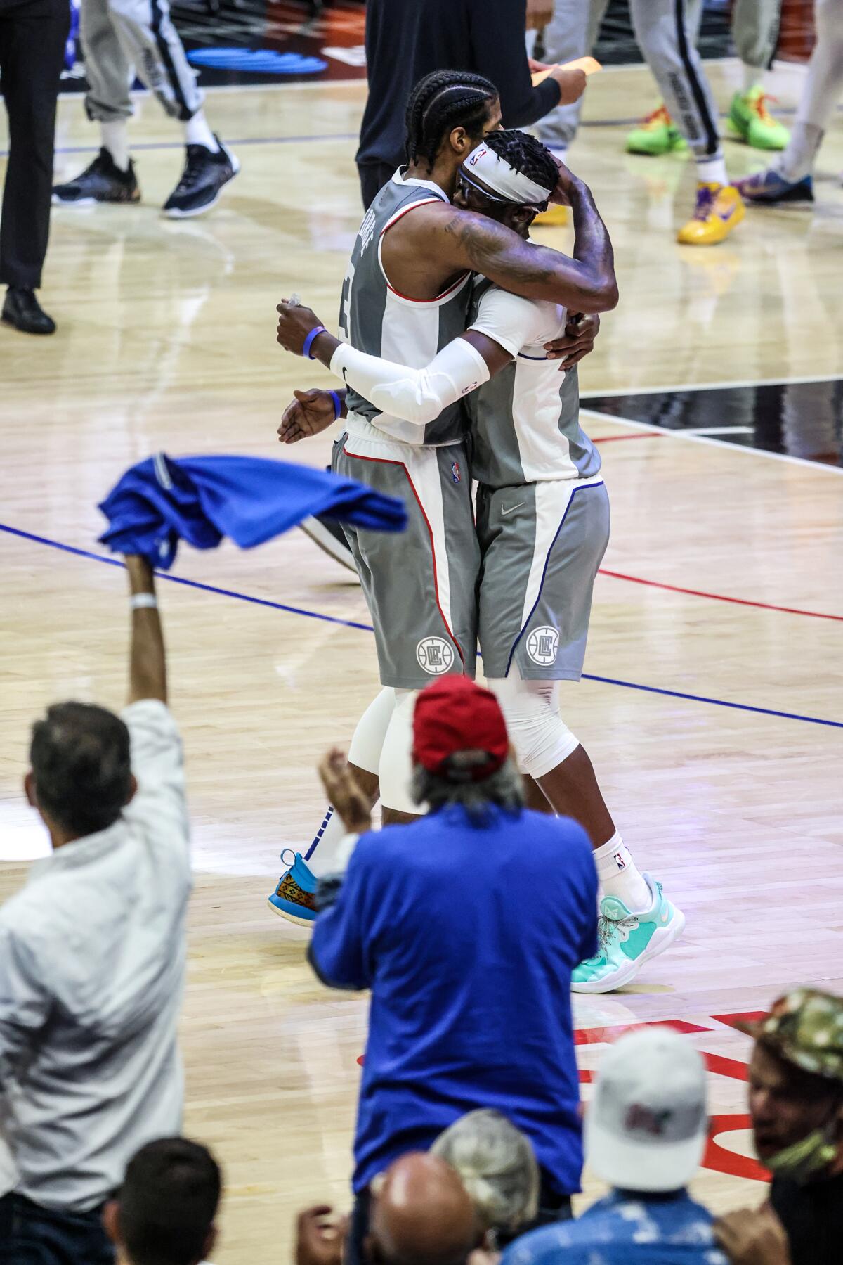 Clippers forward Paul George hugs guard Reggie Jackson as they rally against the Suns in the second half of Game 4.