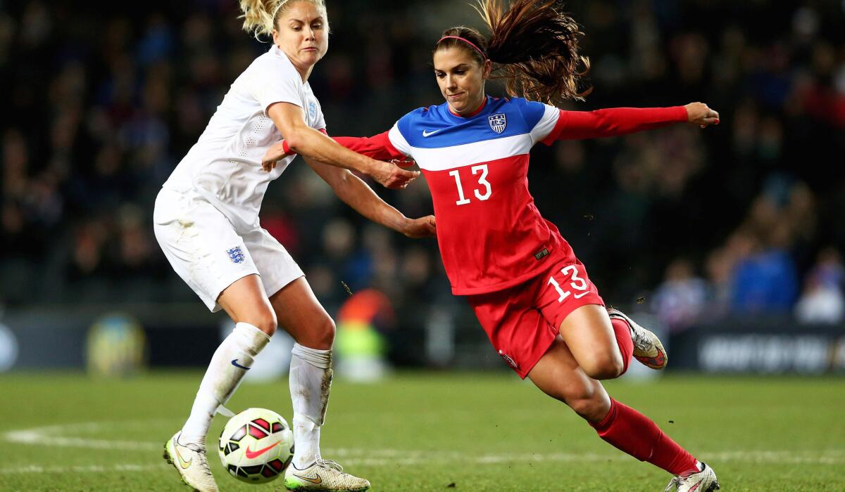 U.S. forward Alex Morgan (13) and England defender Steph Houghton vie for the ball during an exhibition game Feb. 13. Morgan is currently sidelined because of an injury with no clear date for a return.