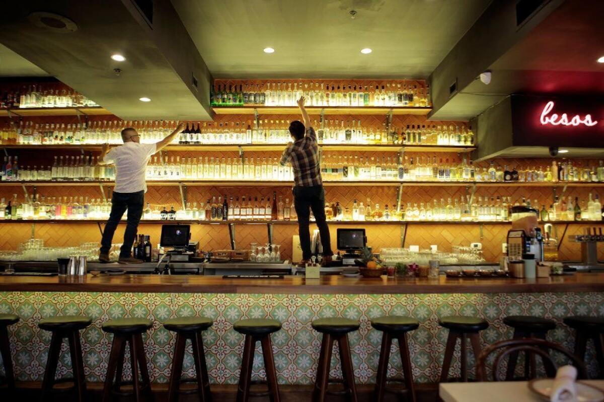 It takes some climbing to reach the highest mezcal bottles in Madre's bar.